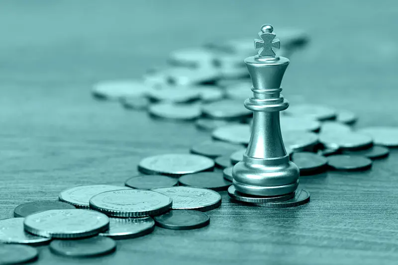 King chess and coins, Image: Kung37 ./ Adobe Stock