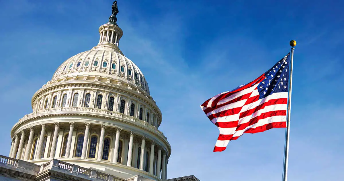 American flag waving in front of the US Capitol / US Congress building. Image: rarrarorro / Adobe Stock